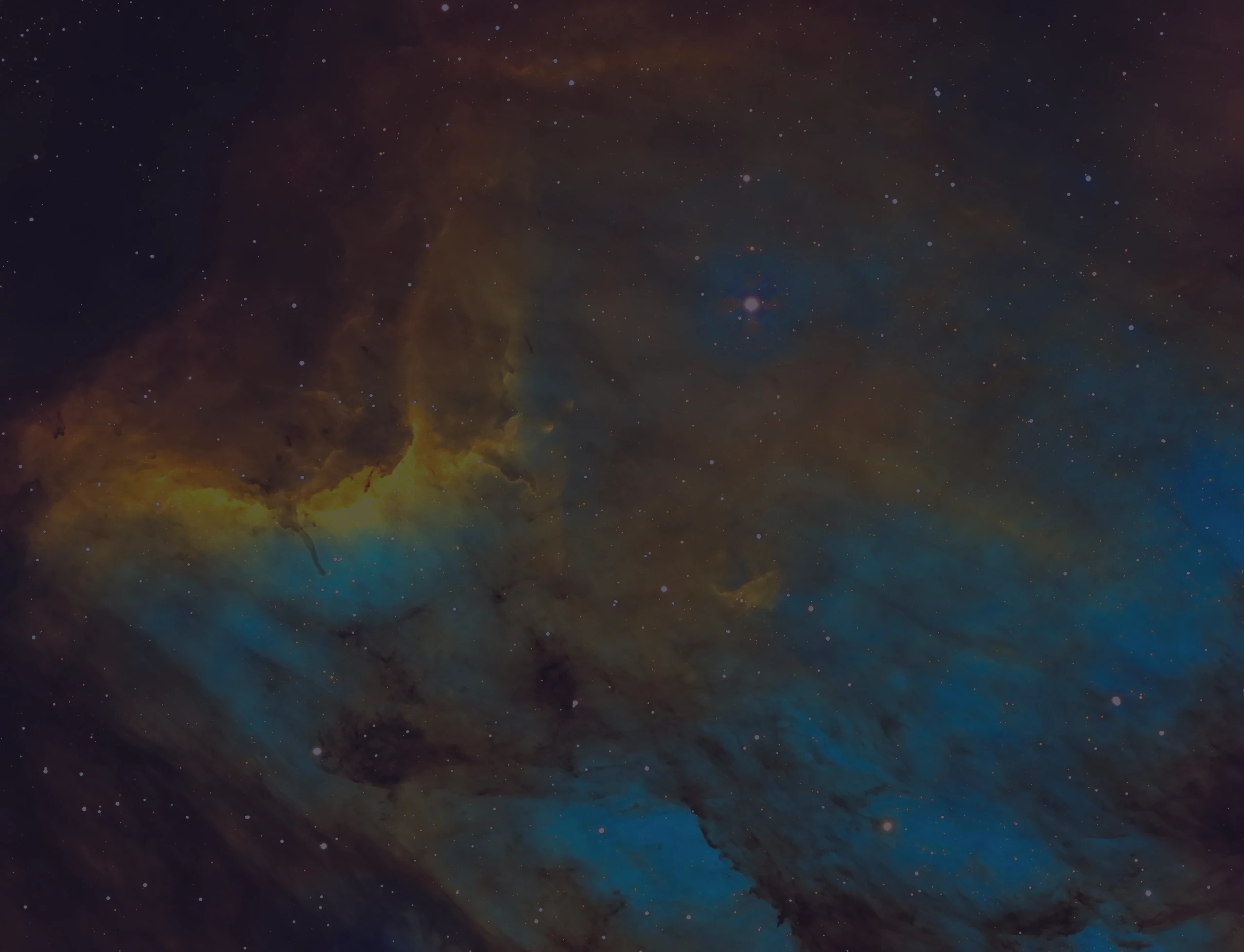 Narrowband astrophotograph of the Pelican Nebula (IC 5070): bright yellow/orange ionised gas edging broad blue-green clouds, with dark dust lanes and scattered stars.