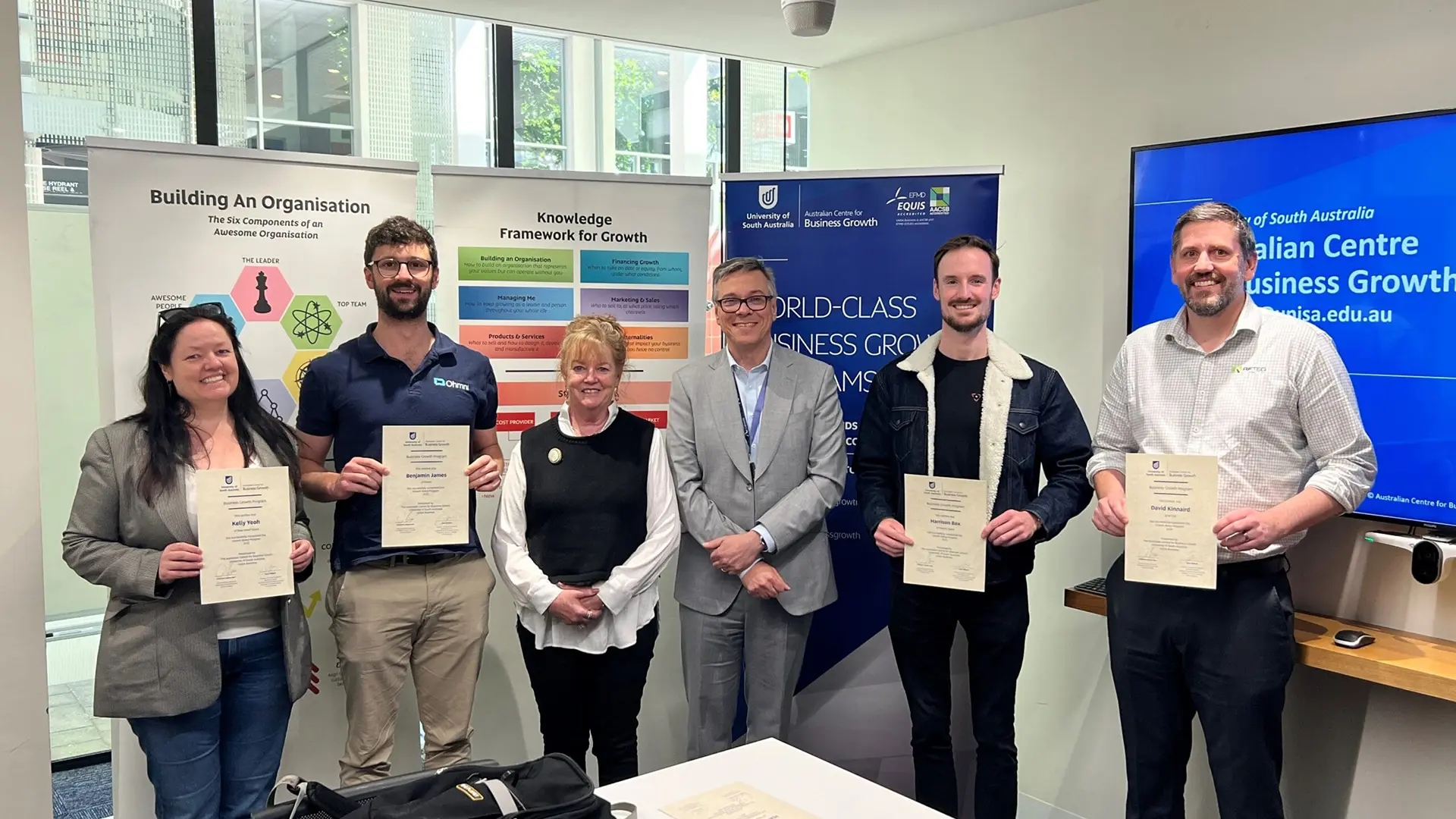 SASIC-Growth-Ramp-2025-graduates-scaled copy A group of graduates holding certificates in a classroom setting