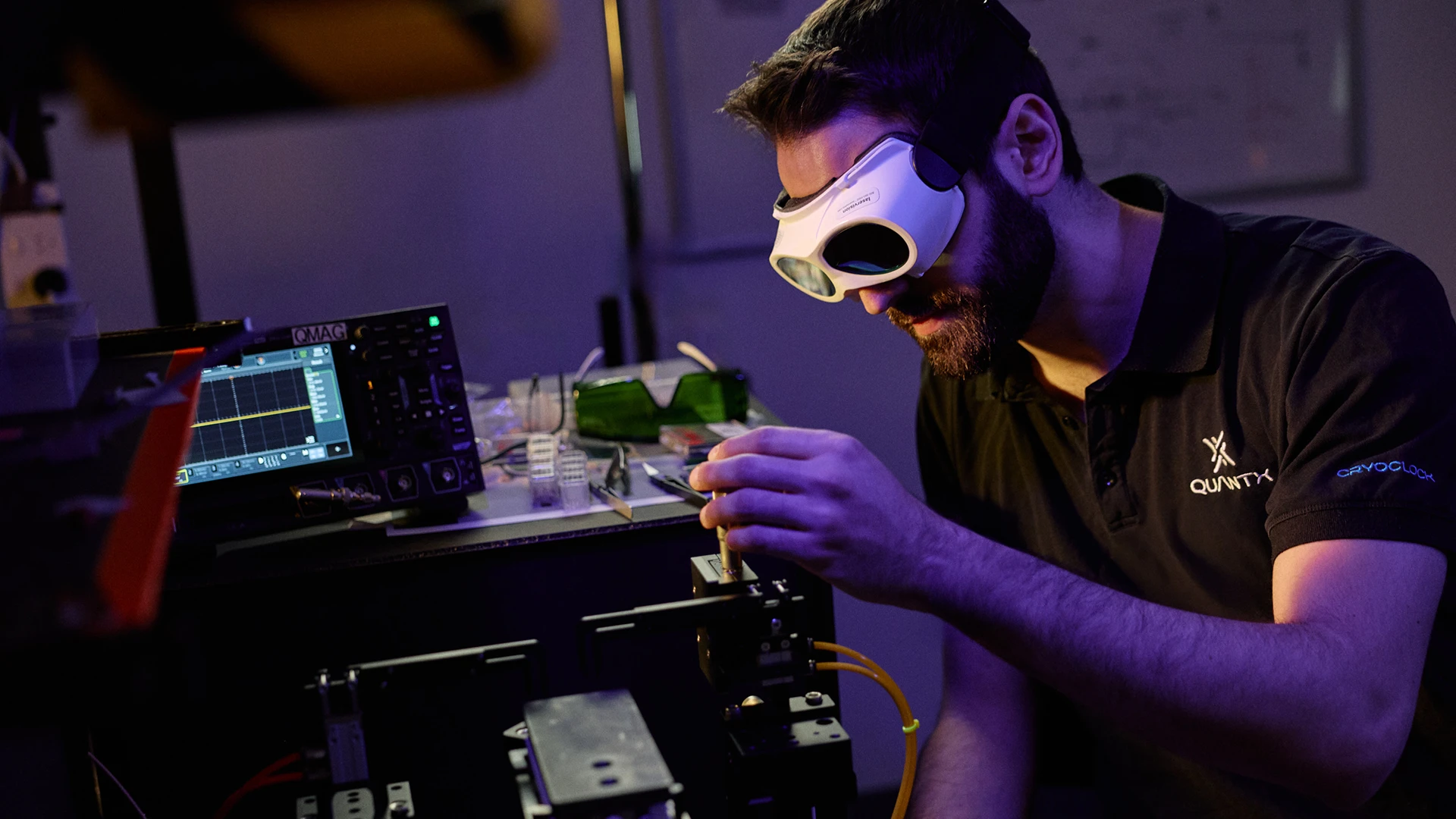 Scientist working in laser lab with white goggles on.