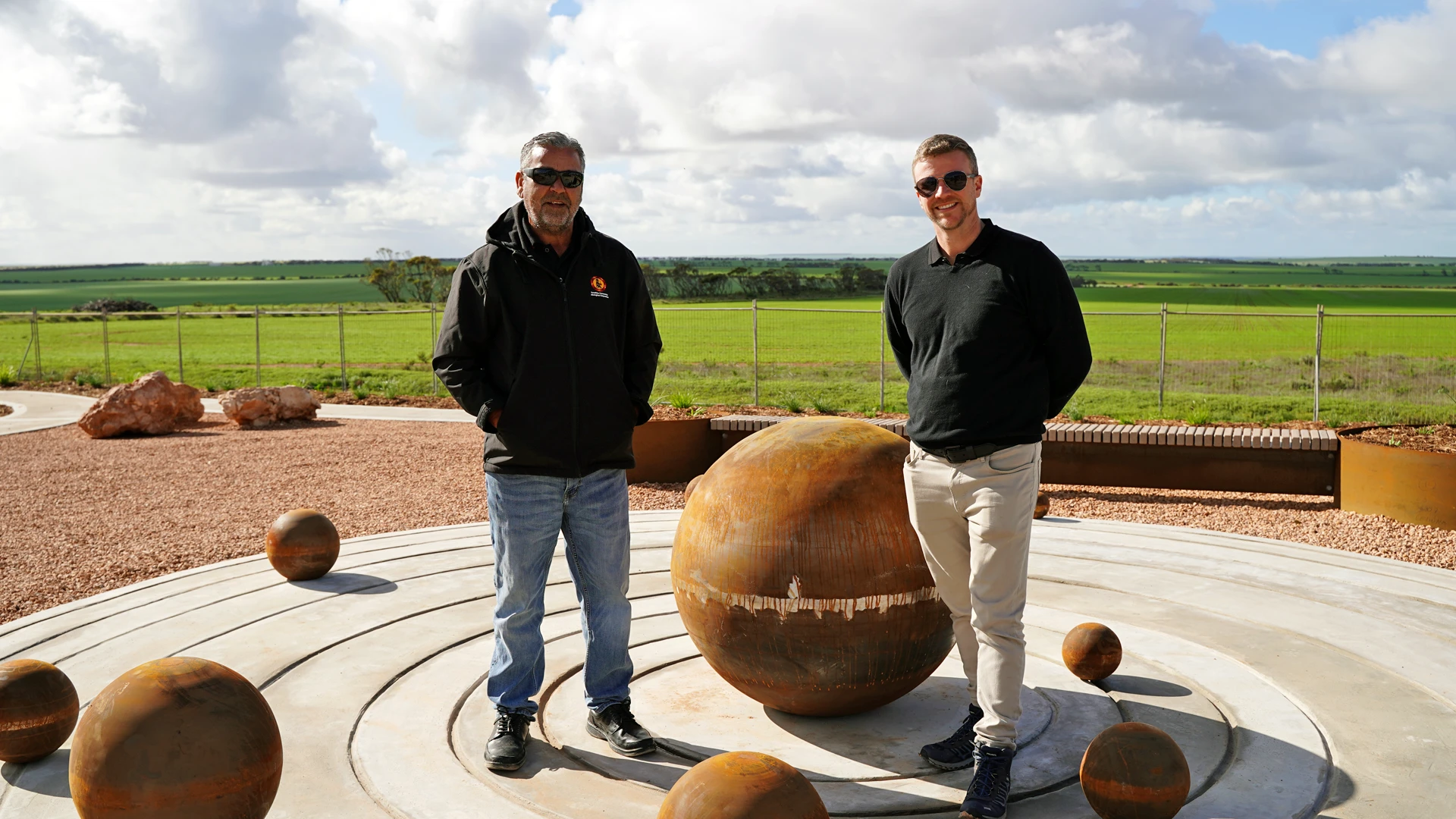 SASIC Regional Engagement Program Two men in an outdoor landscape posing next to a culturally significant statue in regional South Australia