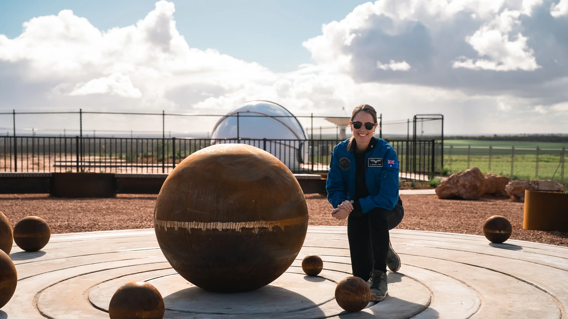 SASIC Regional Engagement Program Australian astronaut kneeling near a culturally significant statue in regional South Australia
