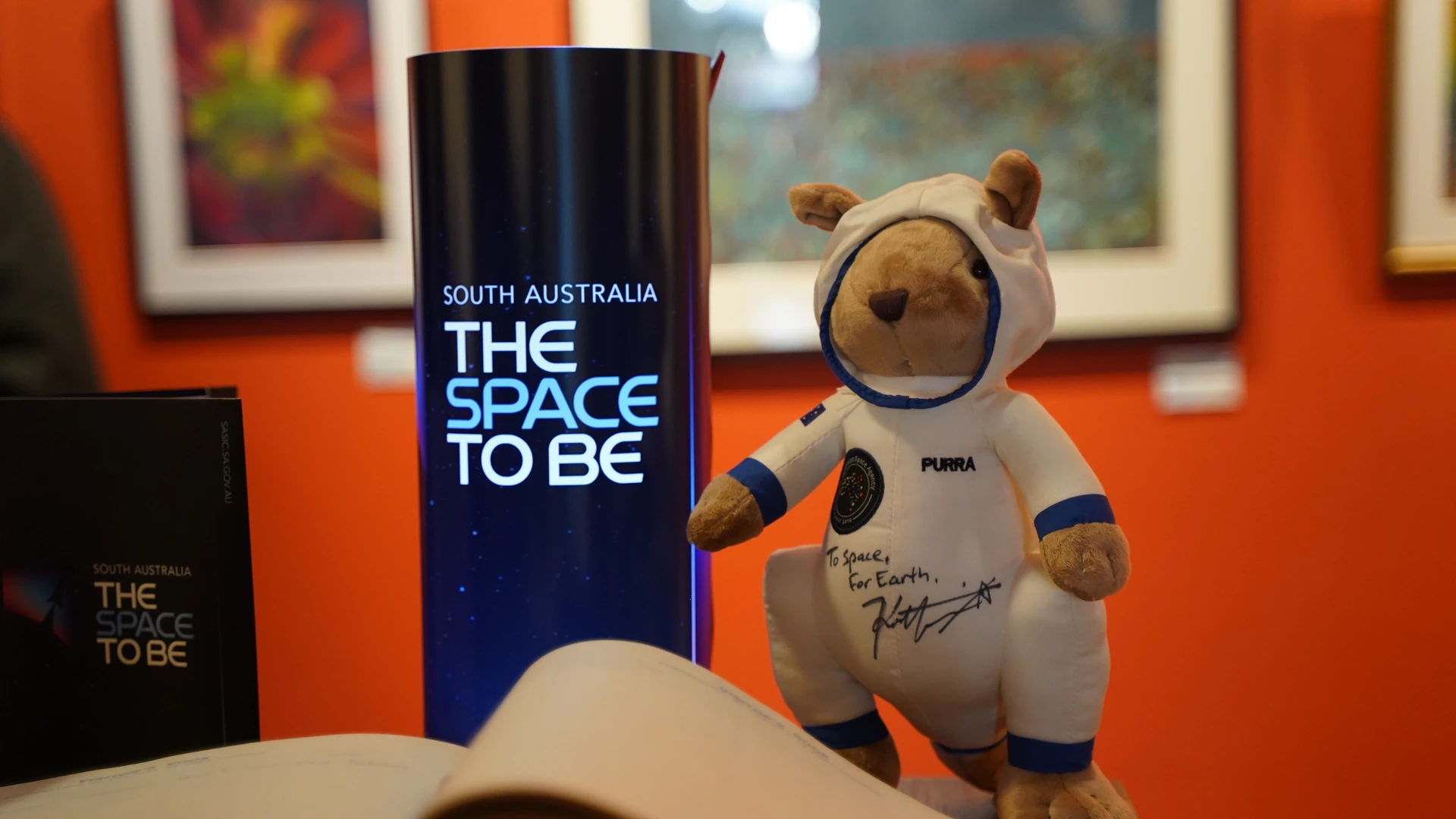 SASIC Regional Engagement Program Astronaut themed kangaroo plush toy next to South Australia Space To Be branding signage
